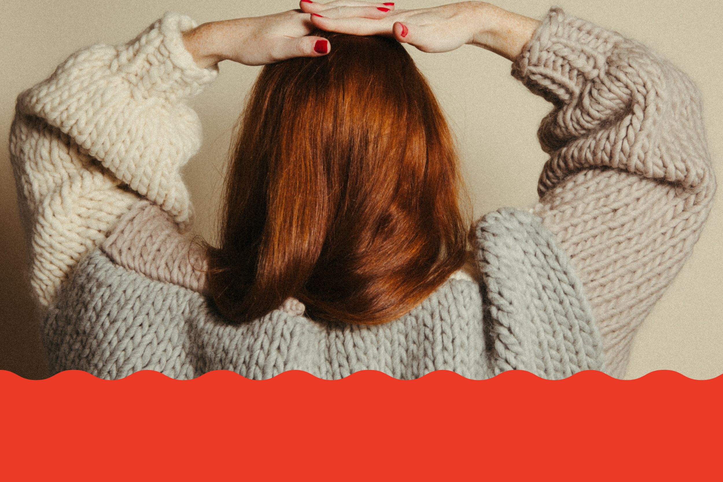 Person wearing a knitted sweater with a neutral background